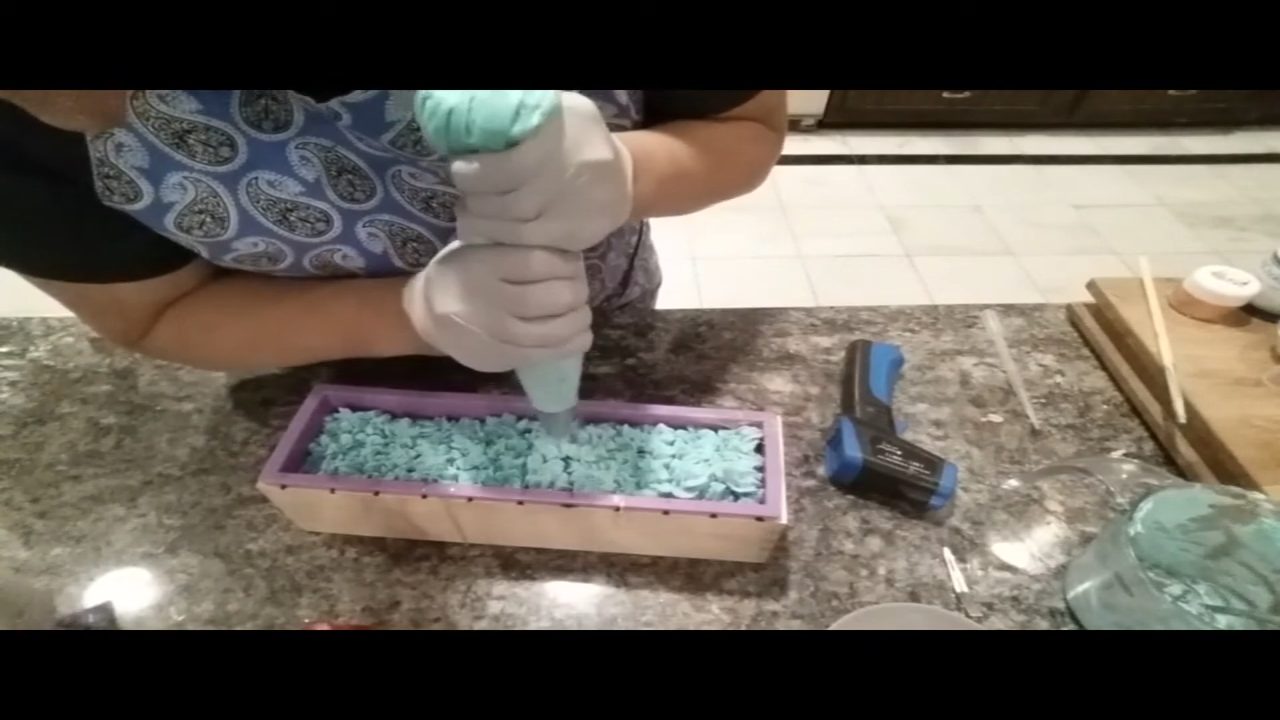 Piping ruffles of soap frosting along the soap loaf