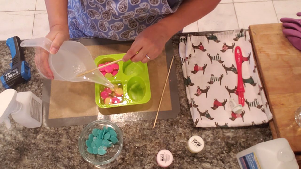 Pouring clear soap and adding green leaf embeds behind the roses