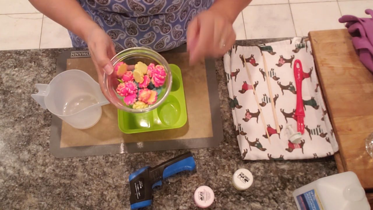 Bowl of pink and yellow mini rose soap embeds and green leaves