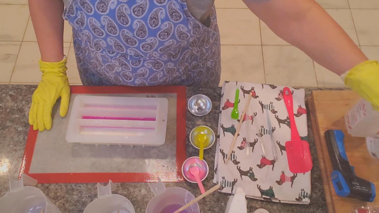 Three poured sections of pink and white soap with dividers in place