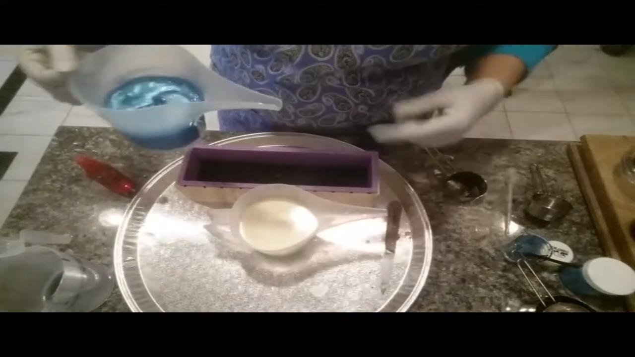 Pouring black soap into a loaf mold