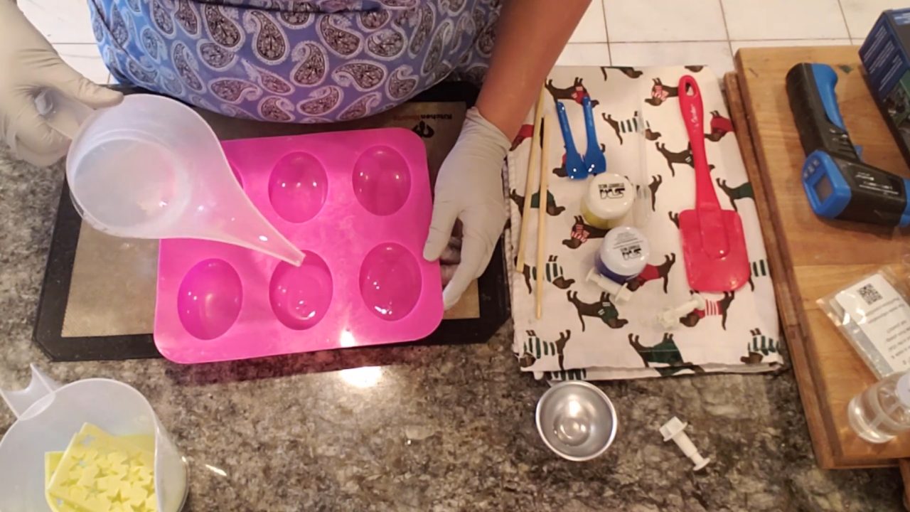Pouring a thin layer of crystal clear melt and pour soap into an oval mold