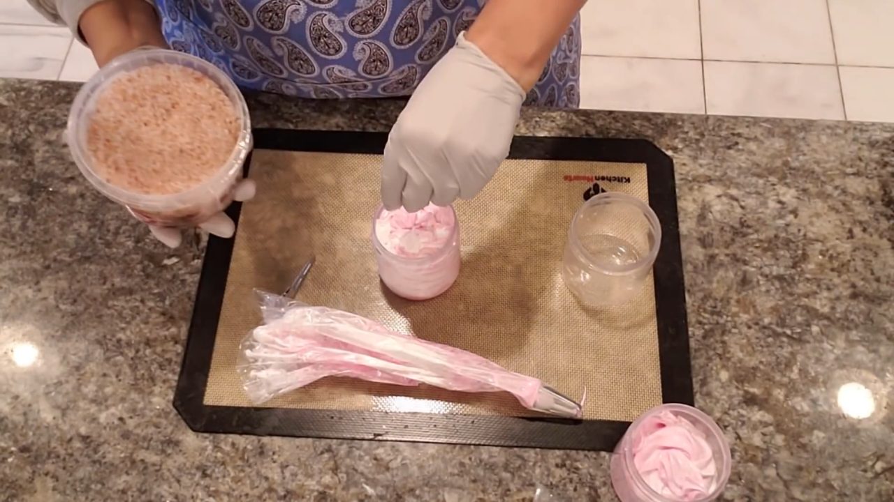 Sprinkling pink Himalayan salt on top of whipped soap in a jar