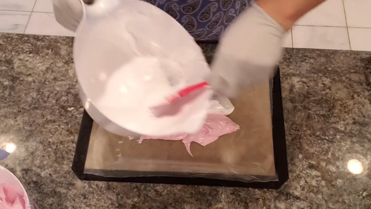 Spooning white and red whipped soap onto press and seal wrap