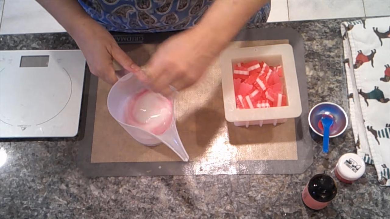 Pouring pale pink soap over the embeds