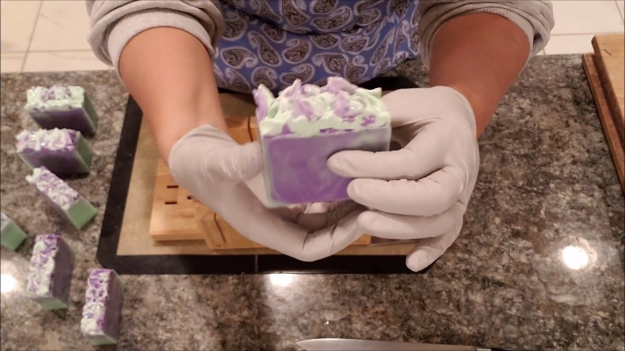 Finished piped floral melt and pour soap bar with purple and green frosting