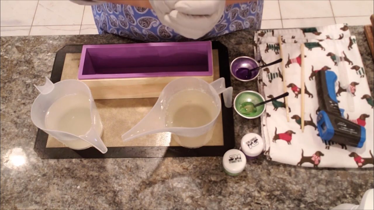 Melting crystal clear melt and pour soap base with titanium dioxide next to a loaf mold