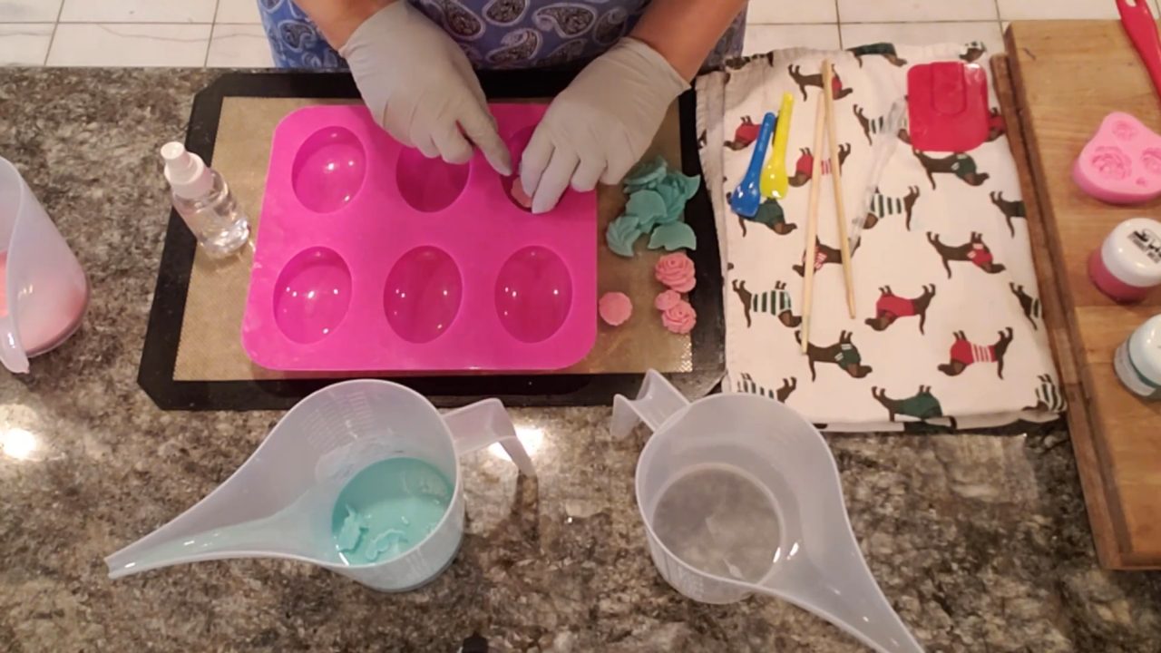 Placing pink soap roses face down in the clear soap