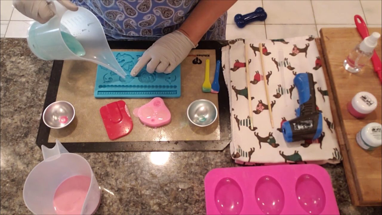 Pouring green shea butter soap into the leaf cavities of a fondant mold