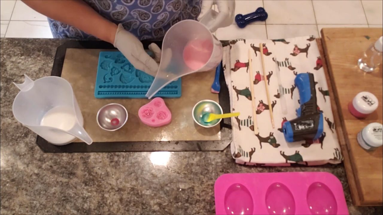 Pouring pink shea butter soap into a rose mold
