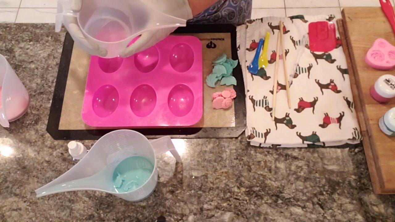 Pouring a thin layer of clear melt and pour soap into an oval mold