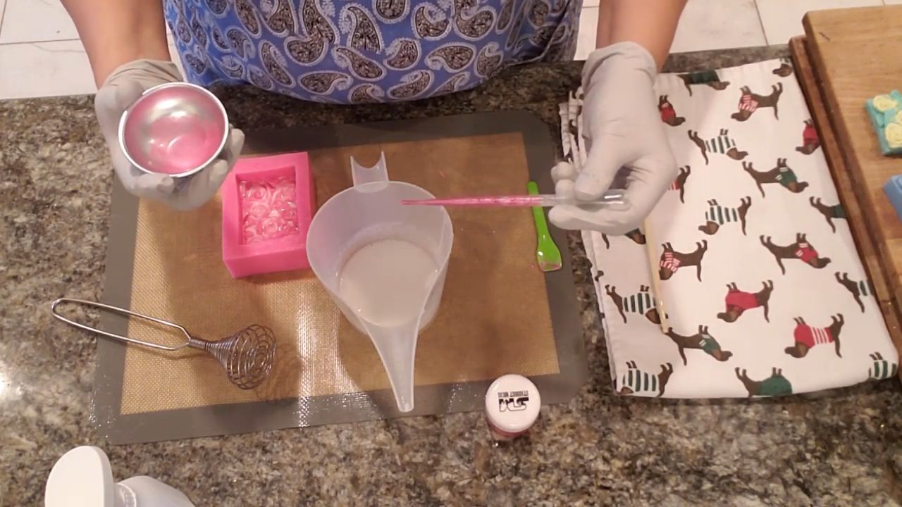 Squirting pink mica into cooled shea butter soap with a pipette