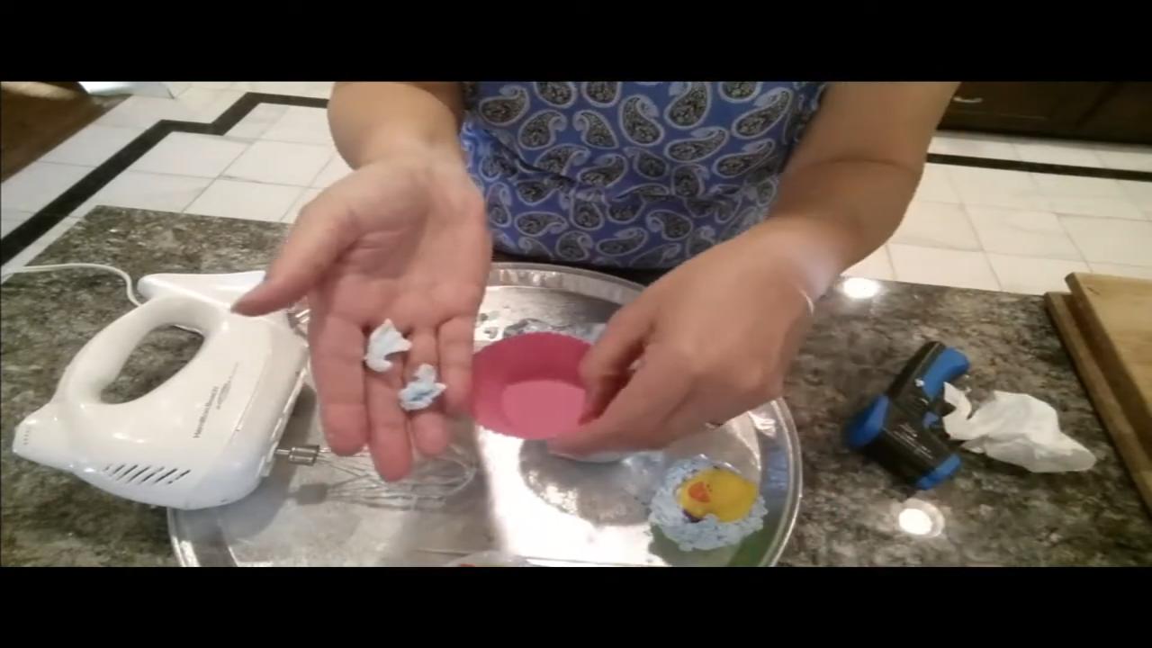 Gluing soap shavings around a rubber duck on a cupcake soap