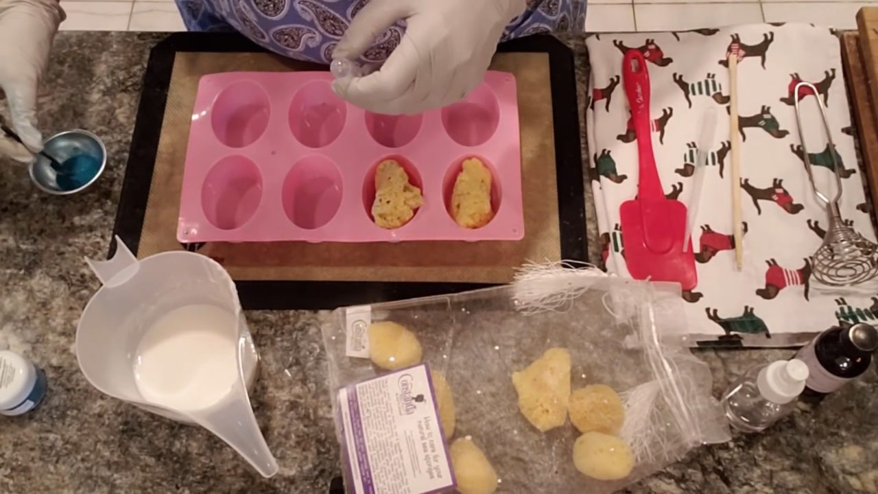 Squirting blue mica mixed with distilled water into cooled shea butter soap