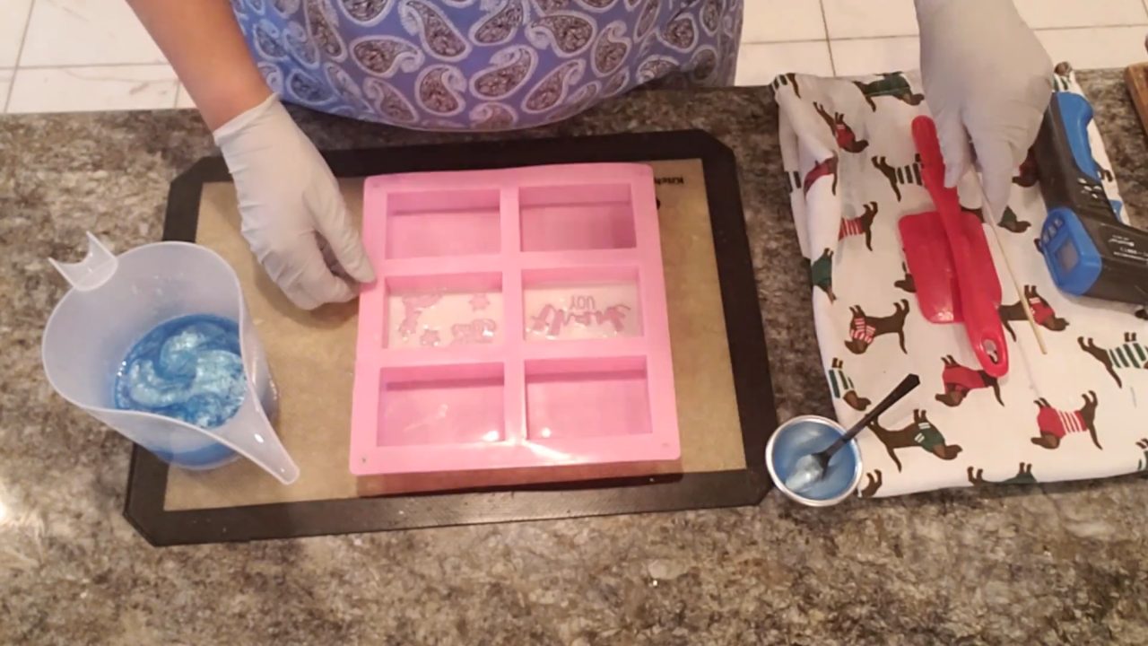 Pouring blue clear soap over the white stamped layer