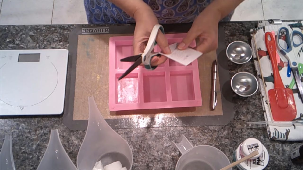 Tucking a water soluble paper picture into clear soap with a skewer