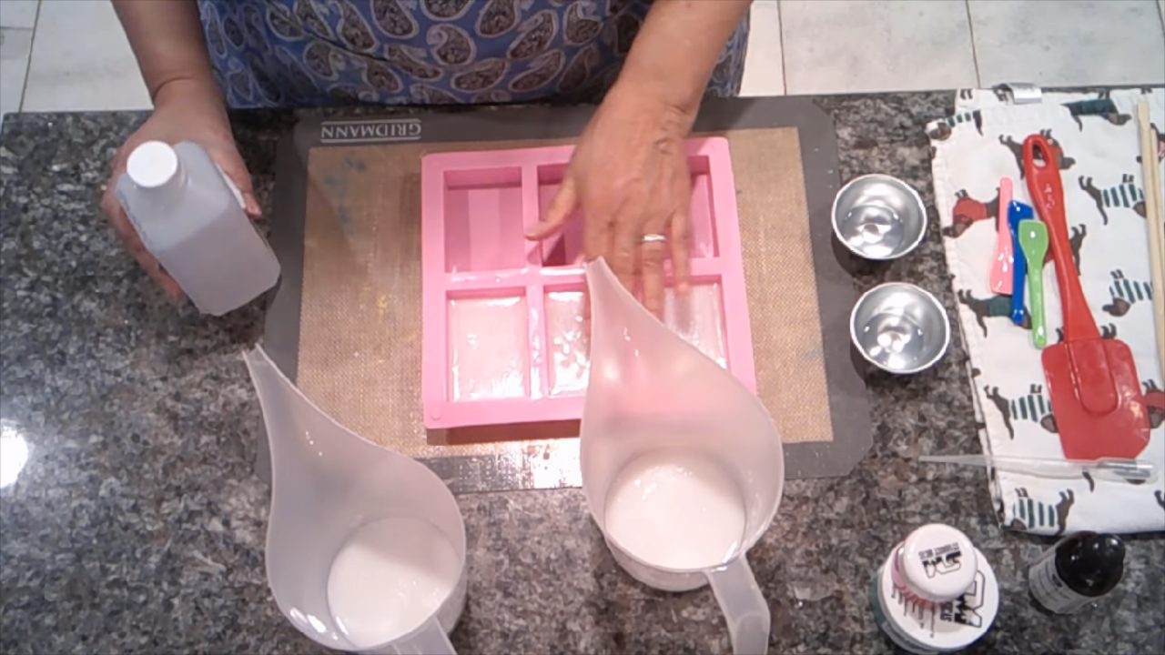 Pouring red shea butter soap as the next layer