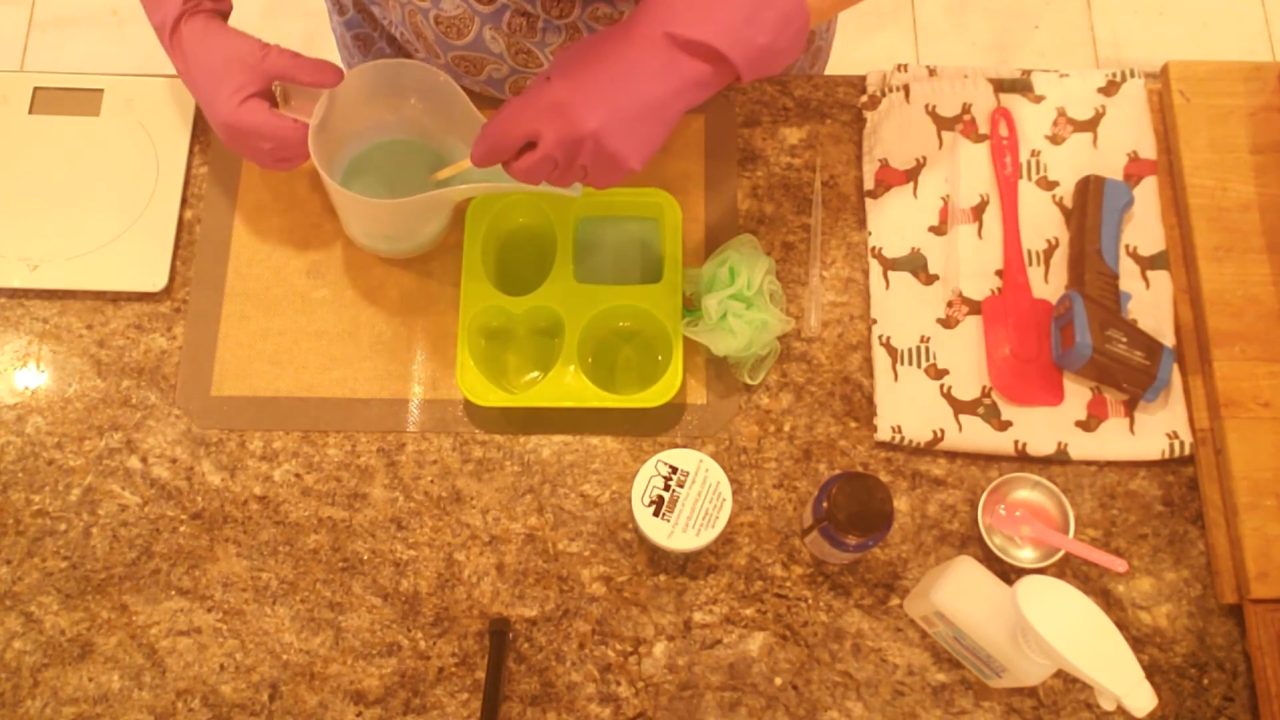 Pouring green shea butter melt and pour soap into a large silicone mold