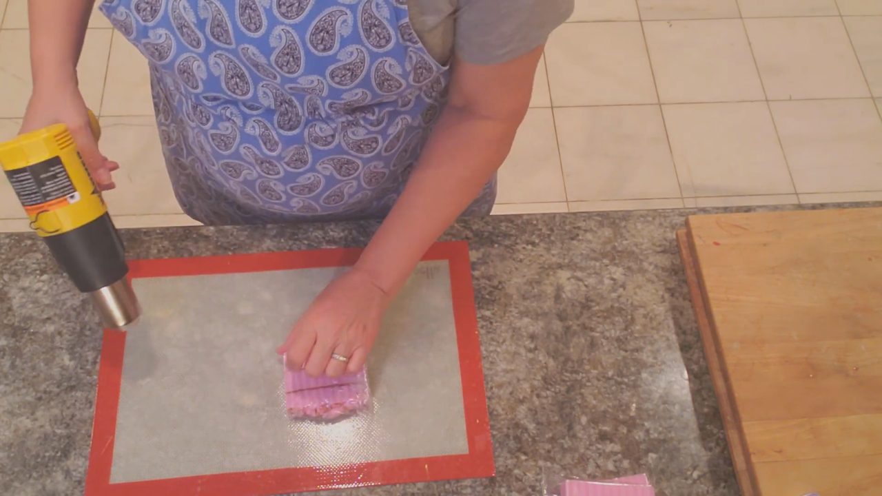 Pressing down the warm shrink wrap edges so there are no sharp corners