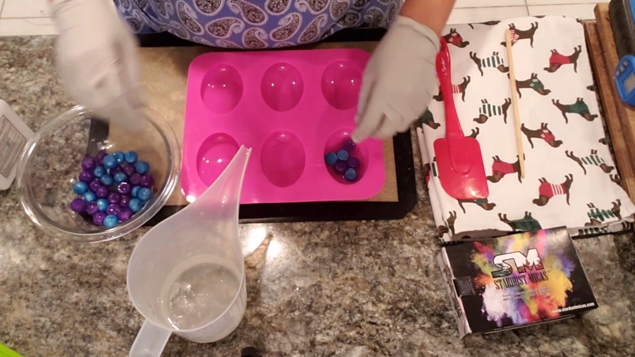 Adding blue and purple ball embeds to clear soap in the mold