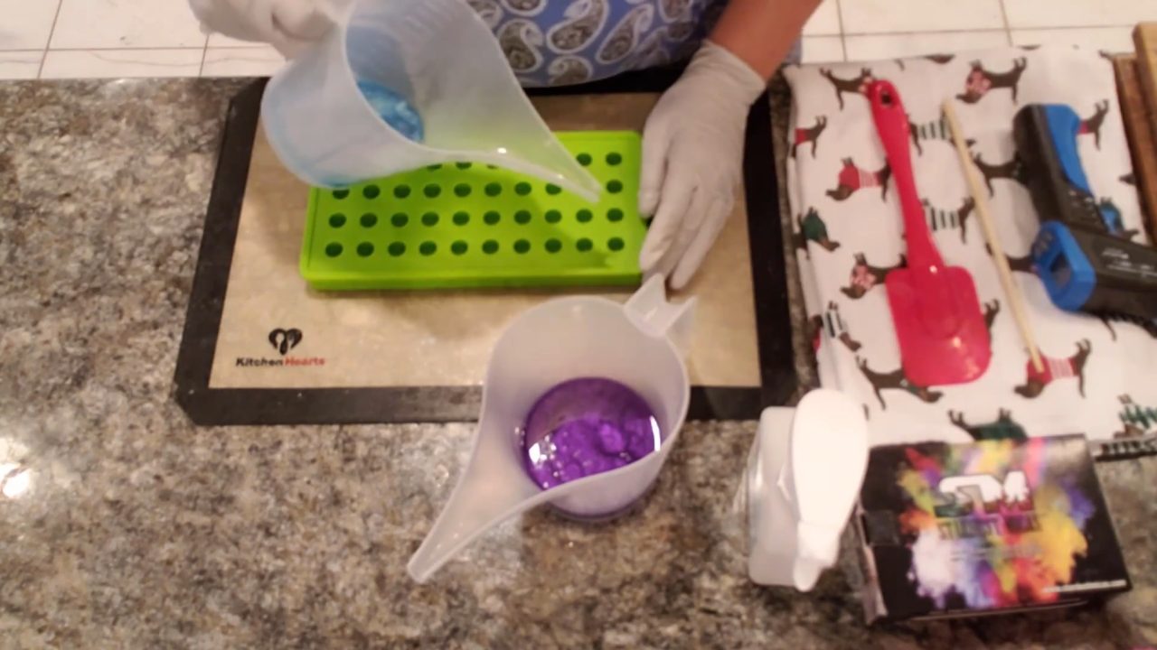 Pouring blue clear soap into a small ball silicone mold
