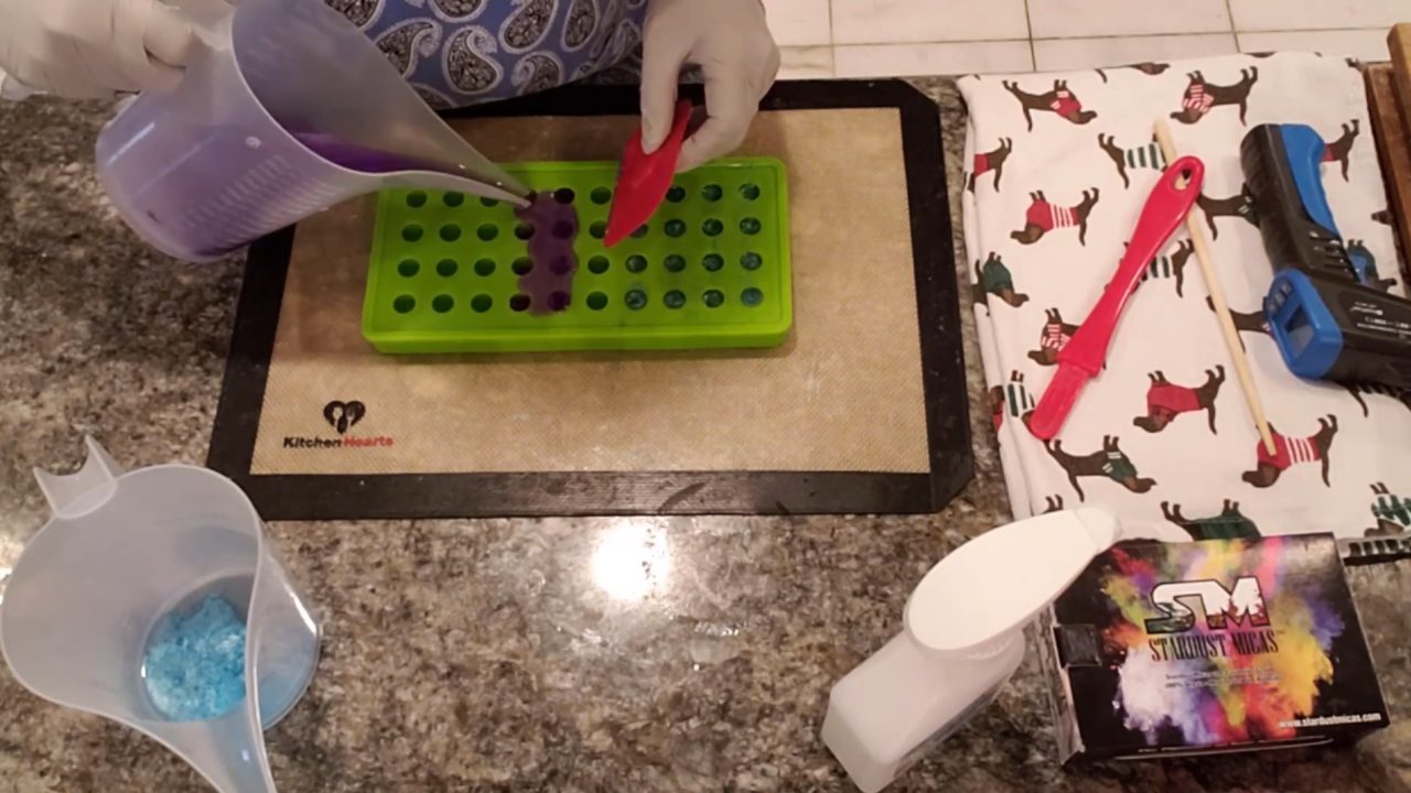 Pouring purple clear soap into the ball embed mold