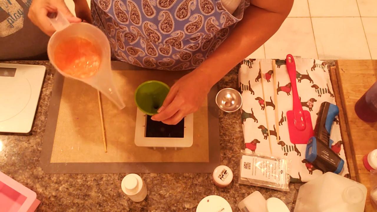 Pouring orange soap through a funnel into the black soap
