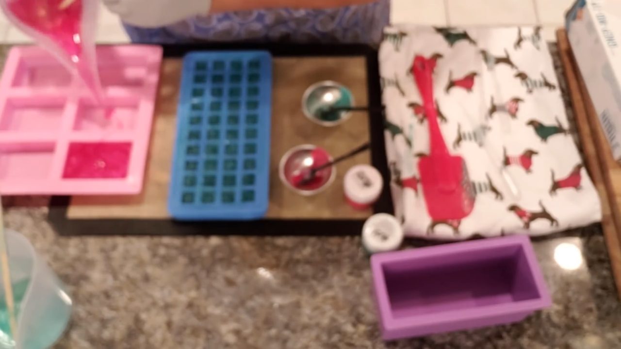 Pouring red clear soap into a silicone mold for embeds