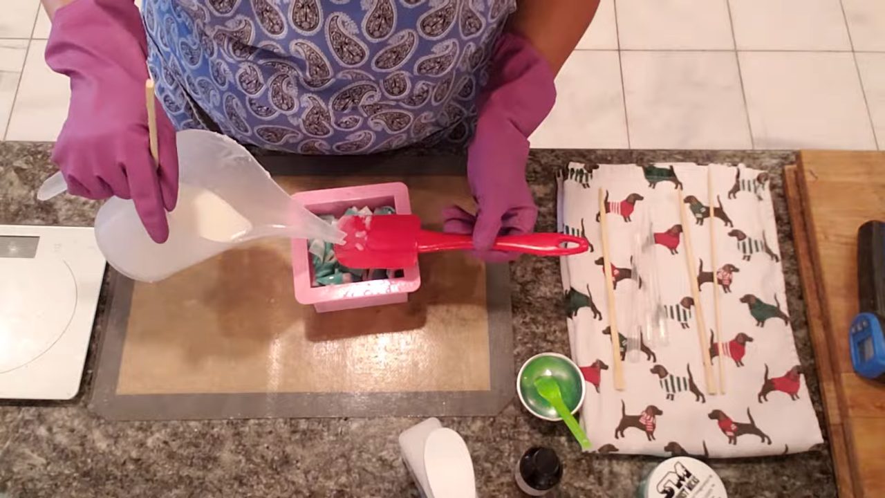 Pouring white shea butter soap over the twisted soap strips