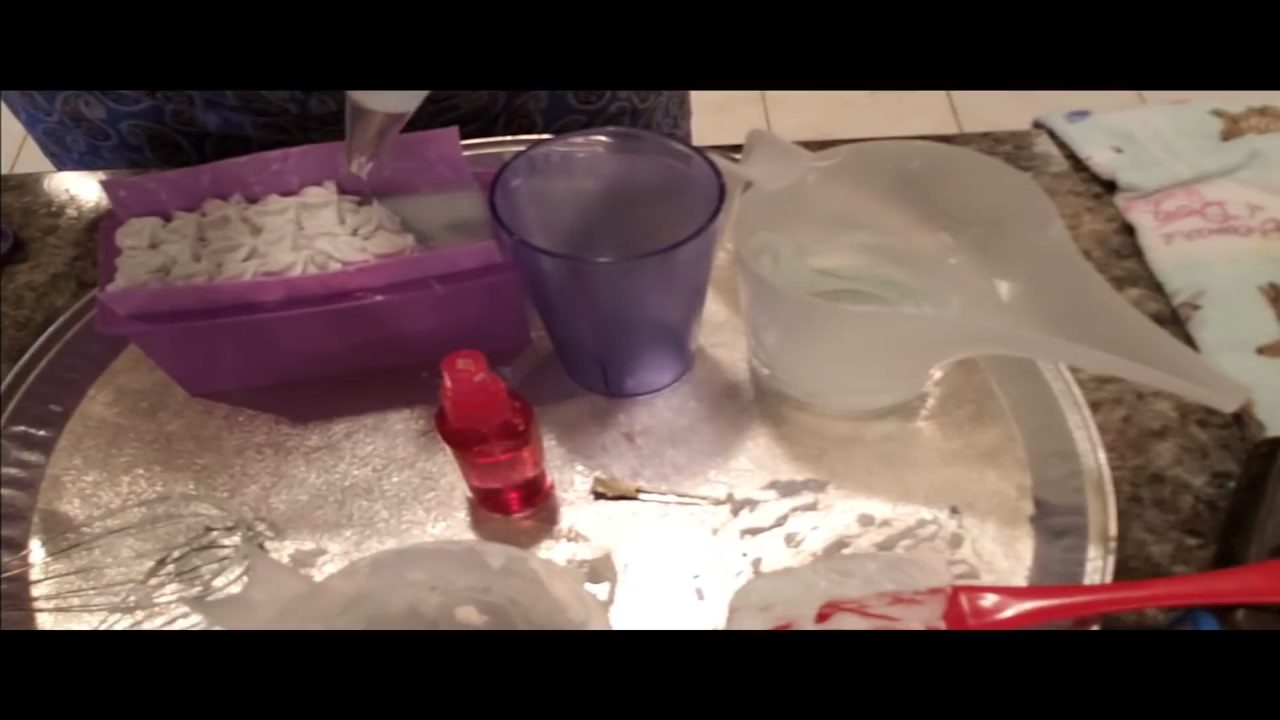 Piped green and purple Melt Whip and Pipe frosting on top of the soap loaf