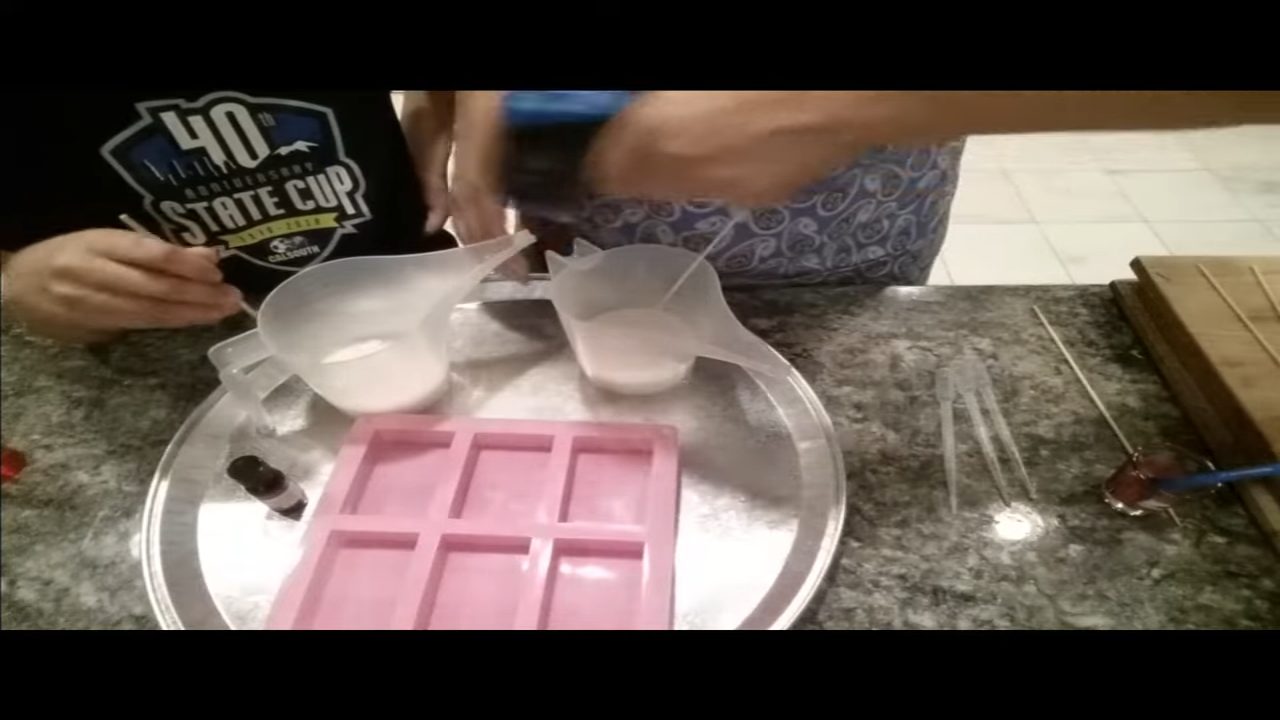 Adding fragrance oil to melted melt and pour soap in a spouted cup