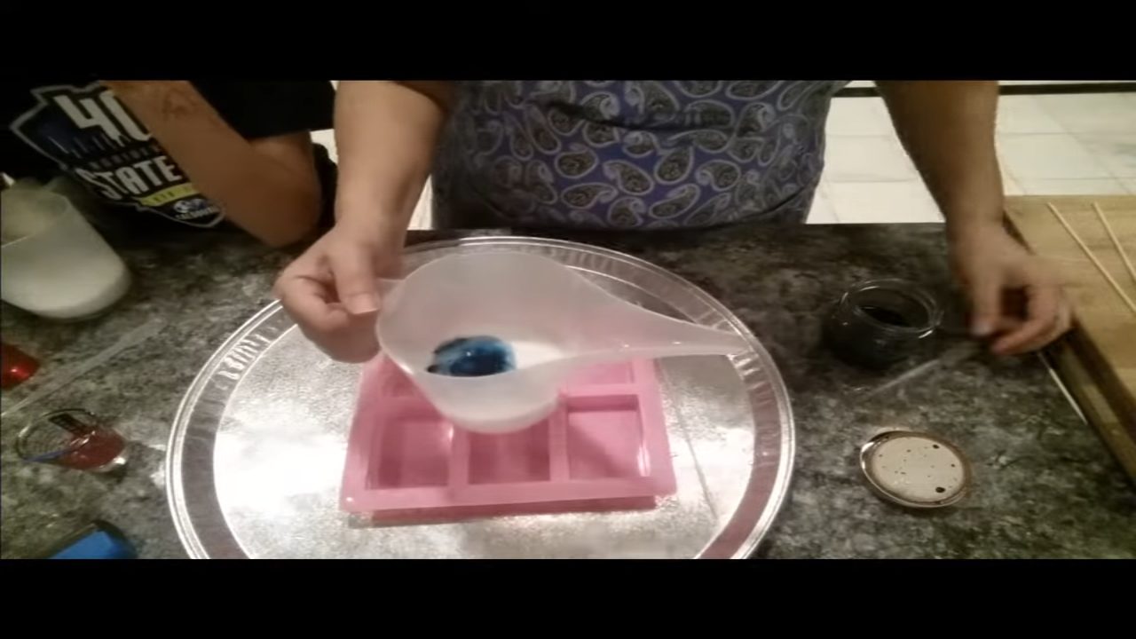 Blue color swirled in a cup of melt and pour soap after one whisk stroke