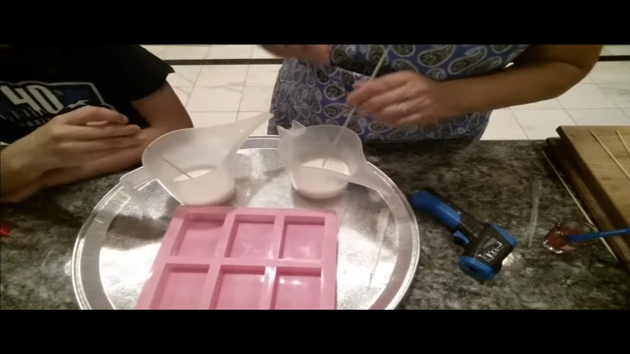 Stirring melted soap base while it cools before swirling