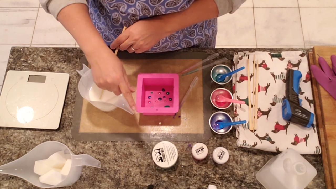 Pouring hot shea butter soap over the color drops
