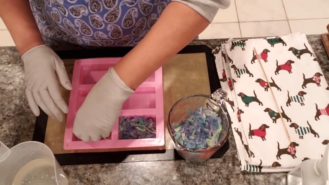 Pressing leftover colorful soap shavings into the mold