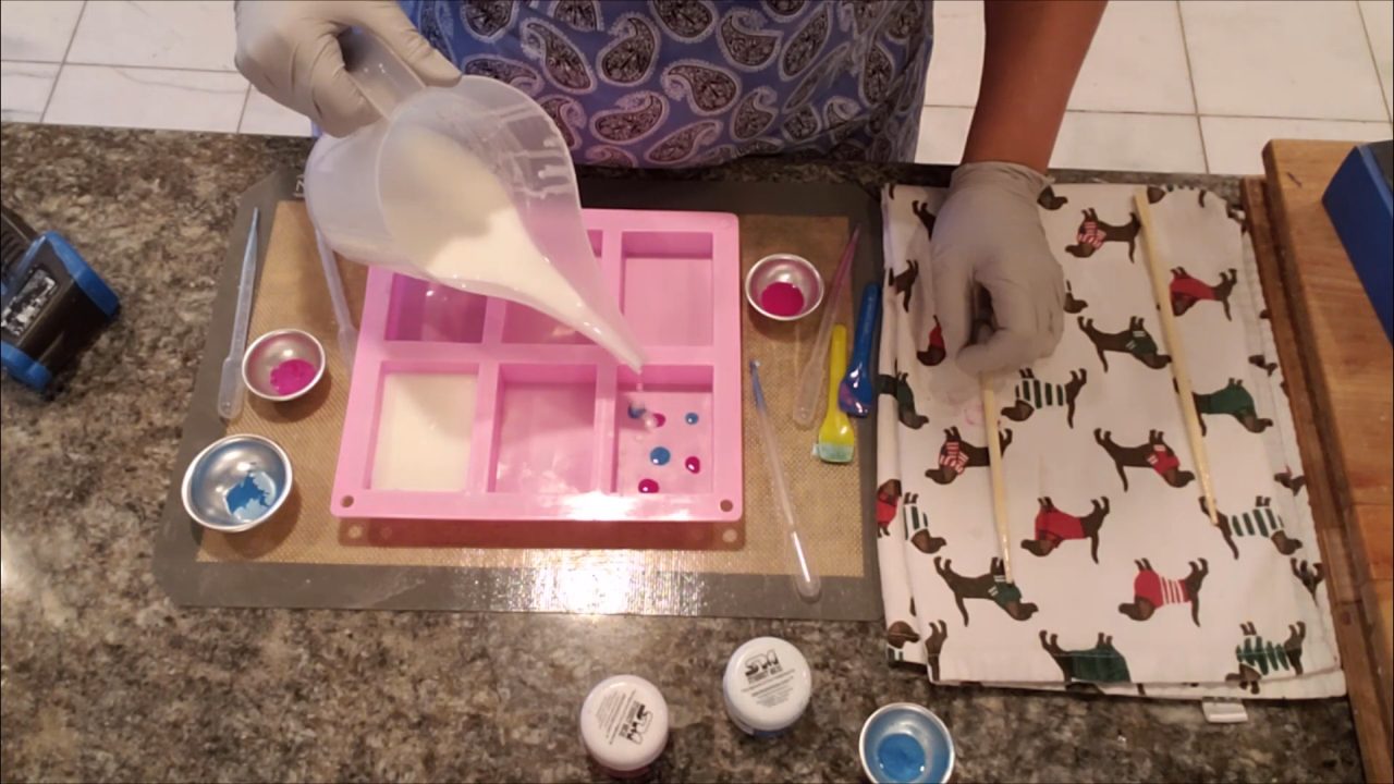 Pouring shea butter melt and pour soap over the color drops