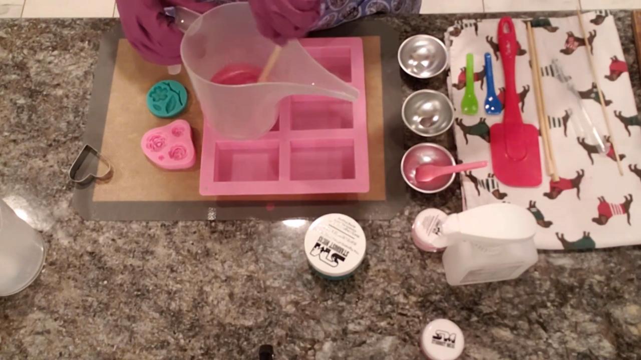 Mixing pink mica into shea butter soap
