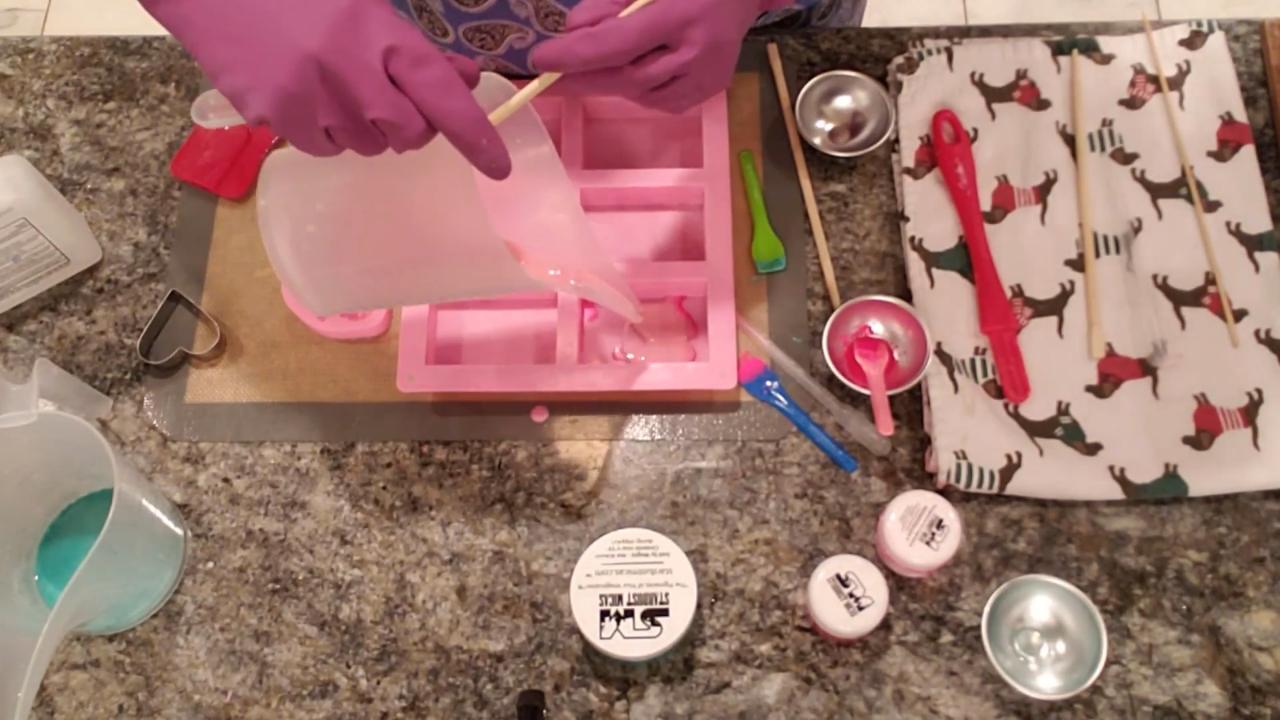 Pouring pink shea butter soap into the bar mold