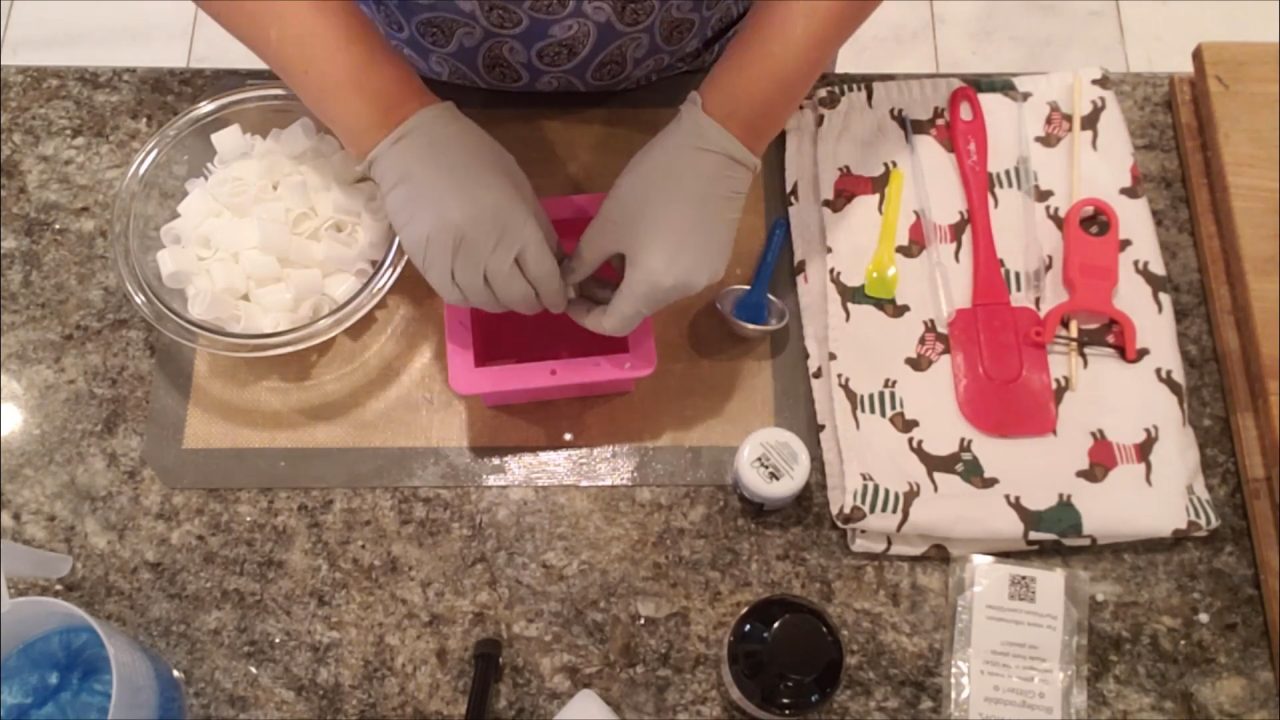 Rolled soap curls lined up in rows in a square soap mold
