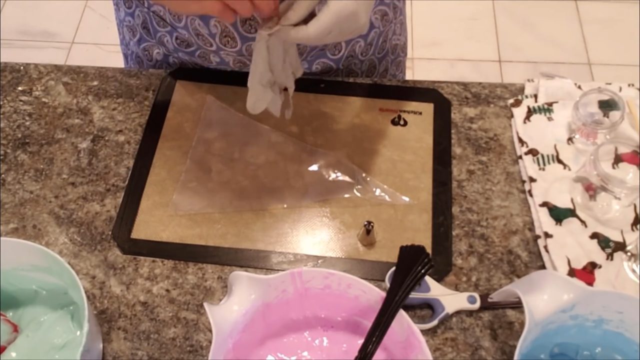 Pink, blue and teal whipped soap ready to pipe, with plastic wrap laid out on a silicone mat